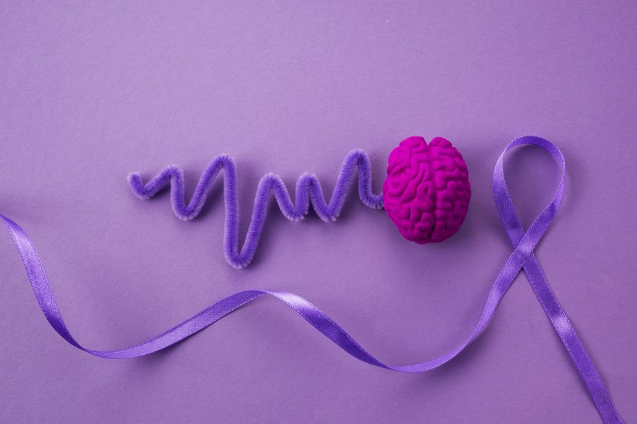 brain with purple wavelengths, next to epilepsy purple ribbon